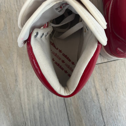 Adidas Originals Metro Attitude Logo Heart Sneakers are women’s sneakers released in 2012, featuring a red suede upper with matching University-Red accents. The design includes dual heart-shaped tongues in white with red Adidas logos, paired with a white sole and laces. Metro Attitude Logo Heart W model (G61014) inspired by Jeremy Scott collaborations