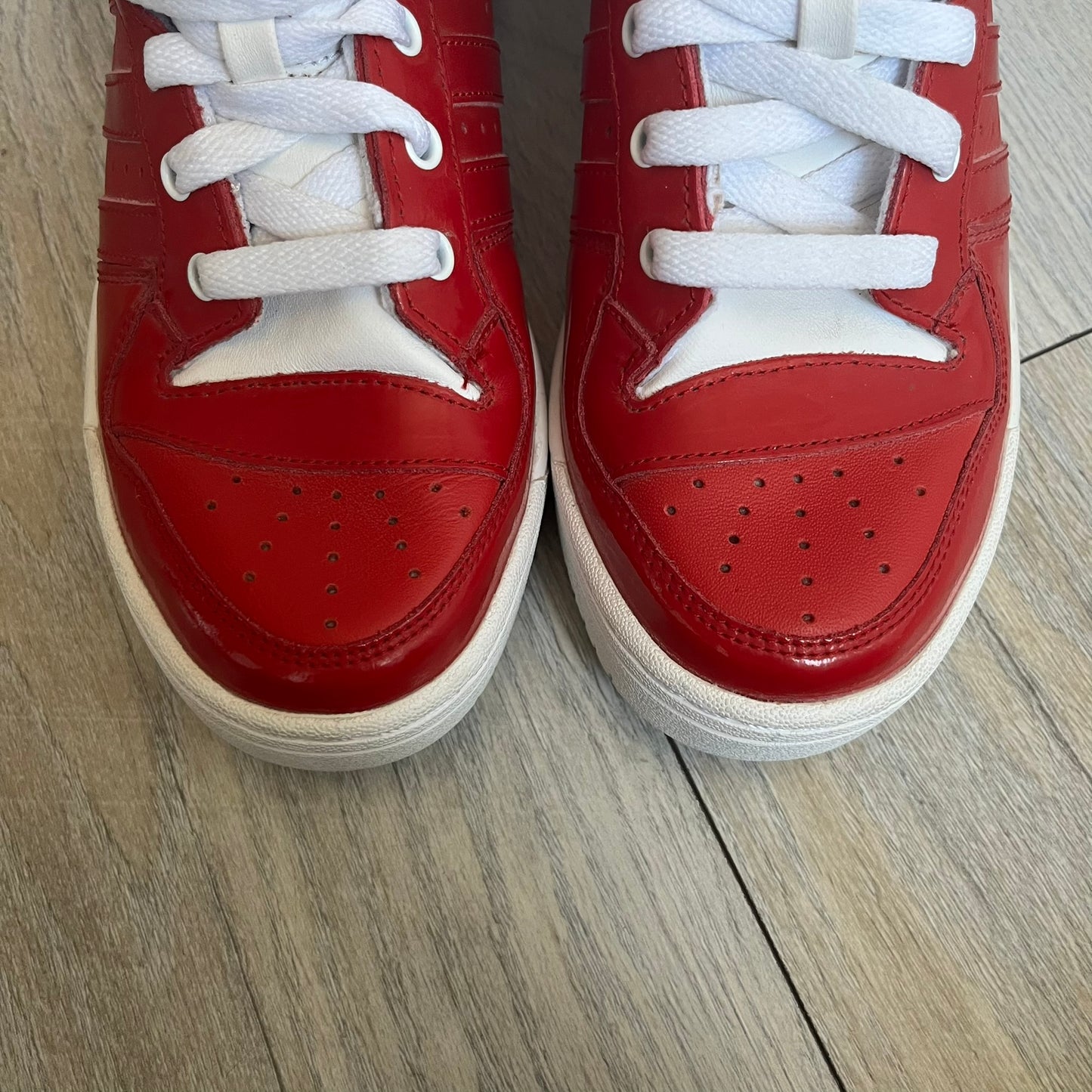Adidas Originals Metro Attitude Logo Heart Sneakers are women’s sneakers released in 2012, featuring a red suede upper with matching University-Red accents. The design includes dual heart-shaped tongues in white with red Adidas logos, paired with a white sole and laces. Metro Attitude Logo Heart W model (G61014) inspired by Jeremy Scott collaborations