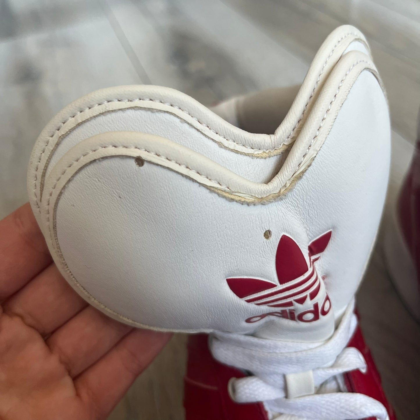 Adidas Originals Metro Attitude Logo Heart Sneakers are women’s sneakers released in 2012, featuring a red suede upper with matching University-Red accents. The design includes dual heart-shaped tongues in white with red Adidas logos, paired with a white sole and laces. Metro Attitude Logo Heart W model (G61014) inspired by Jeremy Scott collaborations