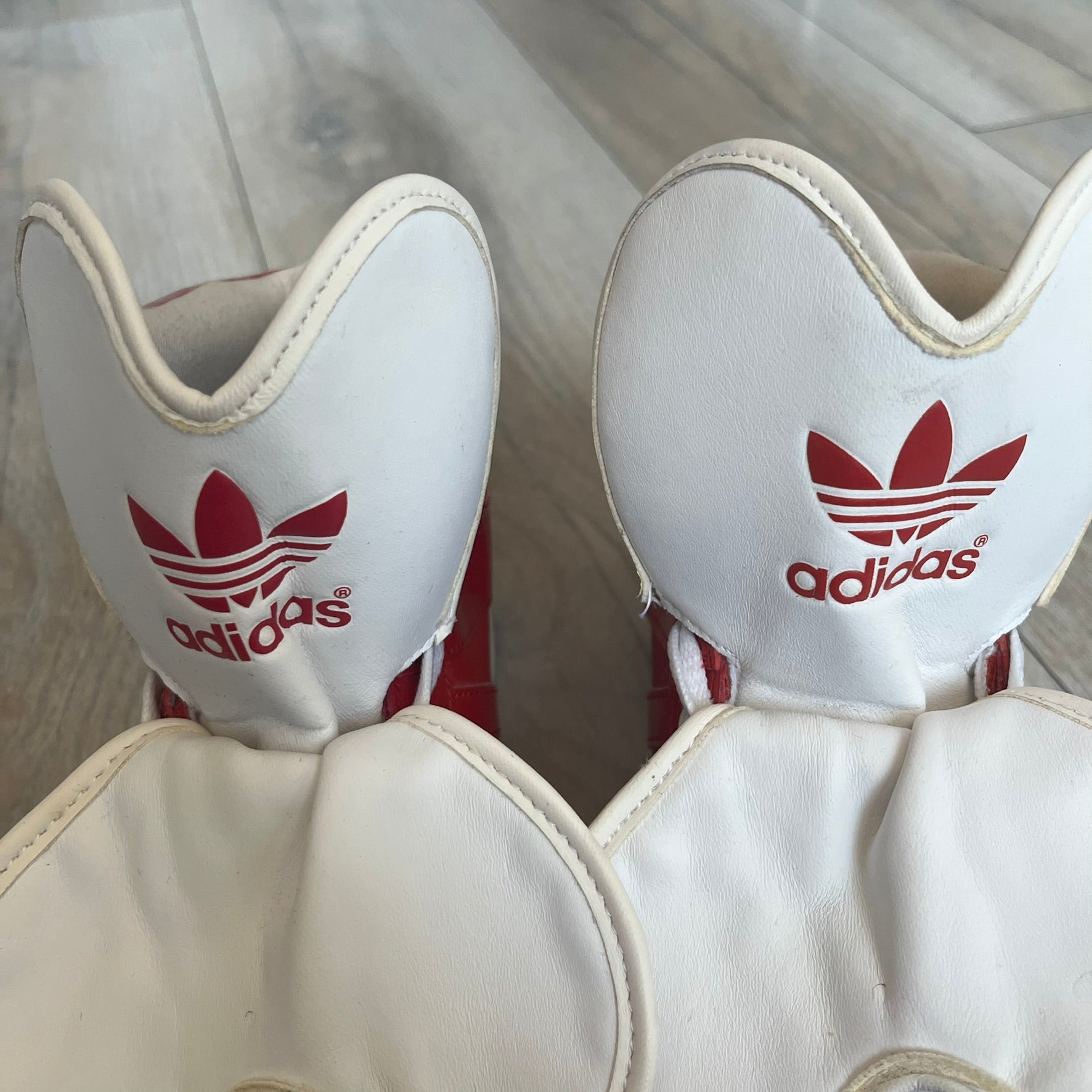 Adidas Originals Metro Attitude Logo Heart Sneakers are women’s sneakers released in 2012, featuring a red suede upper with matching University-Red accents. The design includes dual heart-shaped tongues in white with red Adidas logos, paired with a white sole and laces. Metro Attitude Logo Heart W model (G61014) inspired by Jeremy Scott collaborations