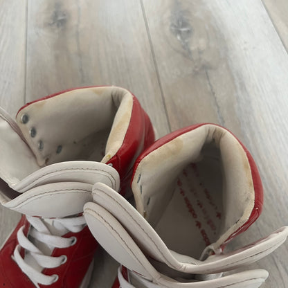 Adidas Originals Metro Attitude Logo Heart Sneakers are women’s sneakers released in 2012, featuring a red suede upper with matching University-Red accents. The design includes dual heart-shaped tongues in white with red Adidas logos, paired with a white sole and laces. Metro Attitude Logo Heart W model (G61014) inspired by Jeremy Scott collaborations.