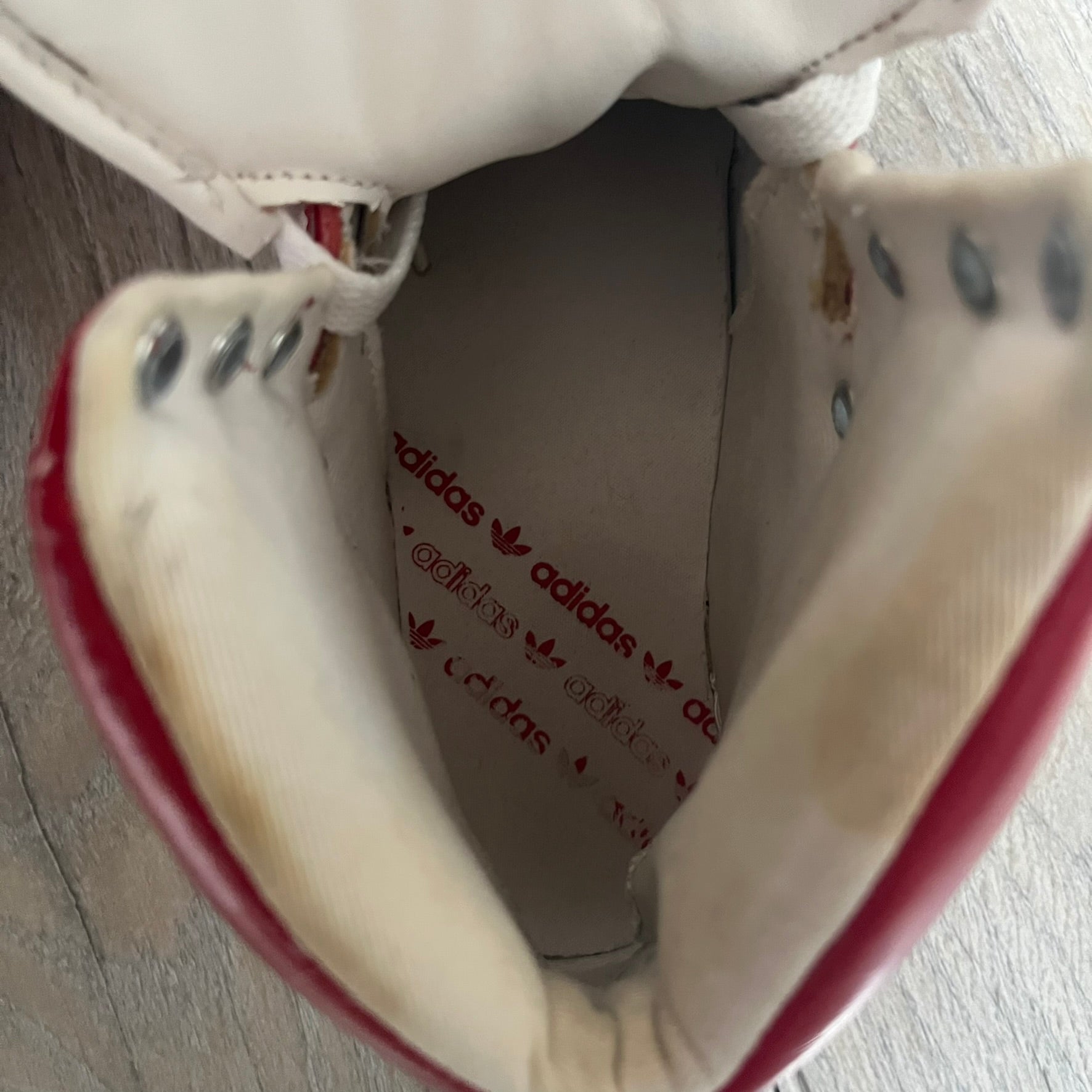 Adidas Originals Metro Attitude Logo Heart Sneakers are women’s sneakers released in 2012, featuring a red suede upper with matching University-Red accents. The design includes dual heart-shaped tongues in white with red Adidas logos, paired with a white sole and laces. Metro Attitude Logo Heart W model (G61014) inspired by Jeremy Scott collaborations.