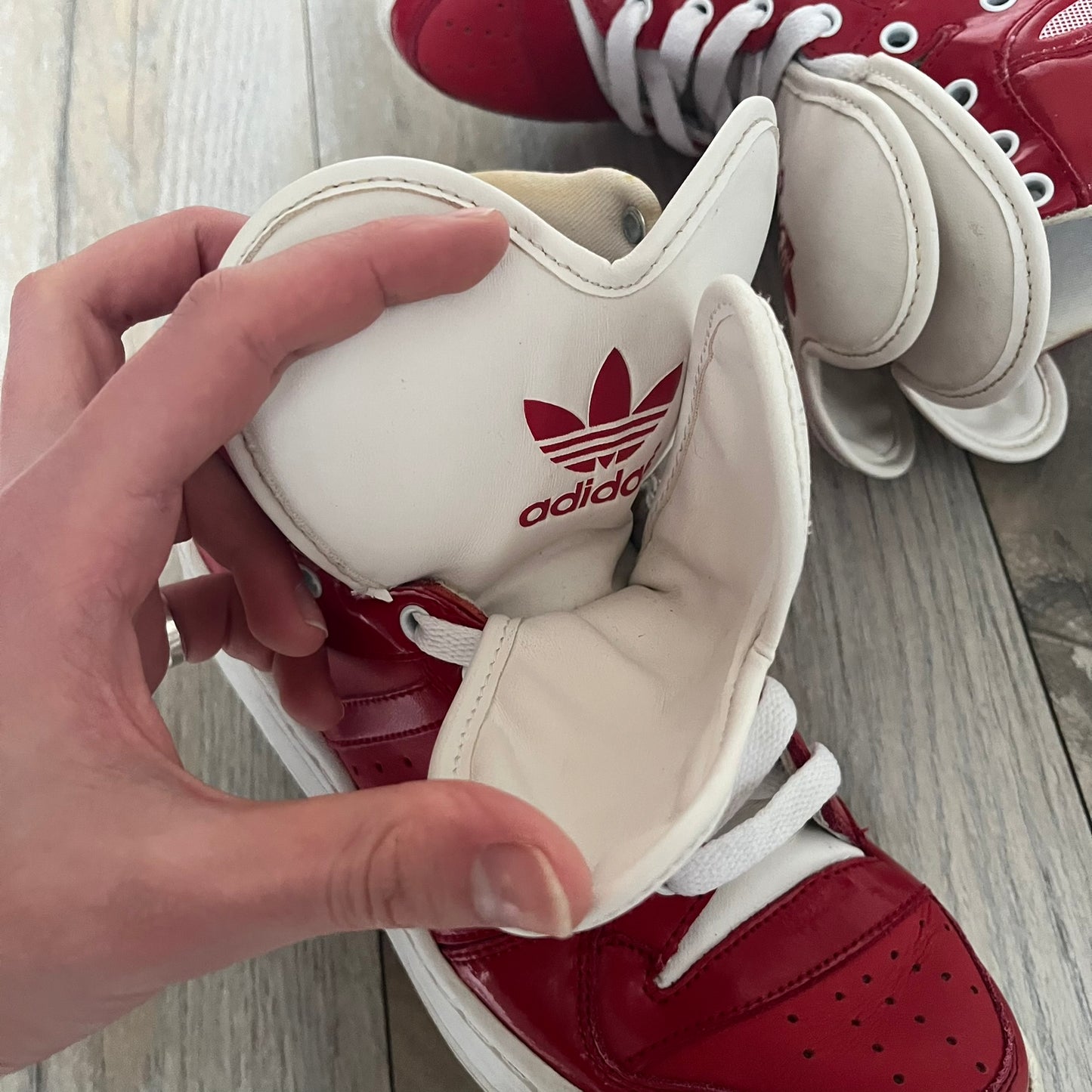 Adidas Originals Metro Attitude Logo Heart Sneakers are women’s sneakers released in 2012, featuring a red suede upper with matching University-Red accents. The design includes dual heart-shaped tongues in white with red Adidas logos, paired with a white sole and laces. Metro Attitude Logo Heart W model (G61014) inspired by Jeremy Scott collaborations.