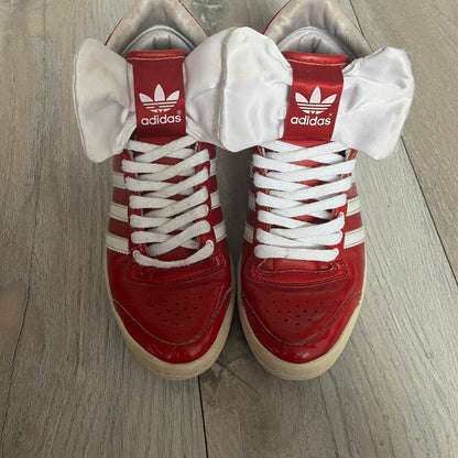 Adidas Originals Top Ten Hi Sleek Bow Sneakers are women’s high-top sneakers in University-Red and white leather. They feature a removable white bow on the tongue, white Adidas stripes, laces, and a white sole. Released under product number G61361, the sneakers include patent leather details for a polished finish.