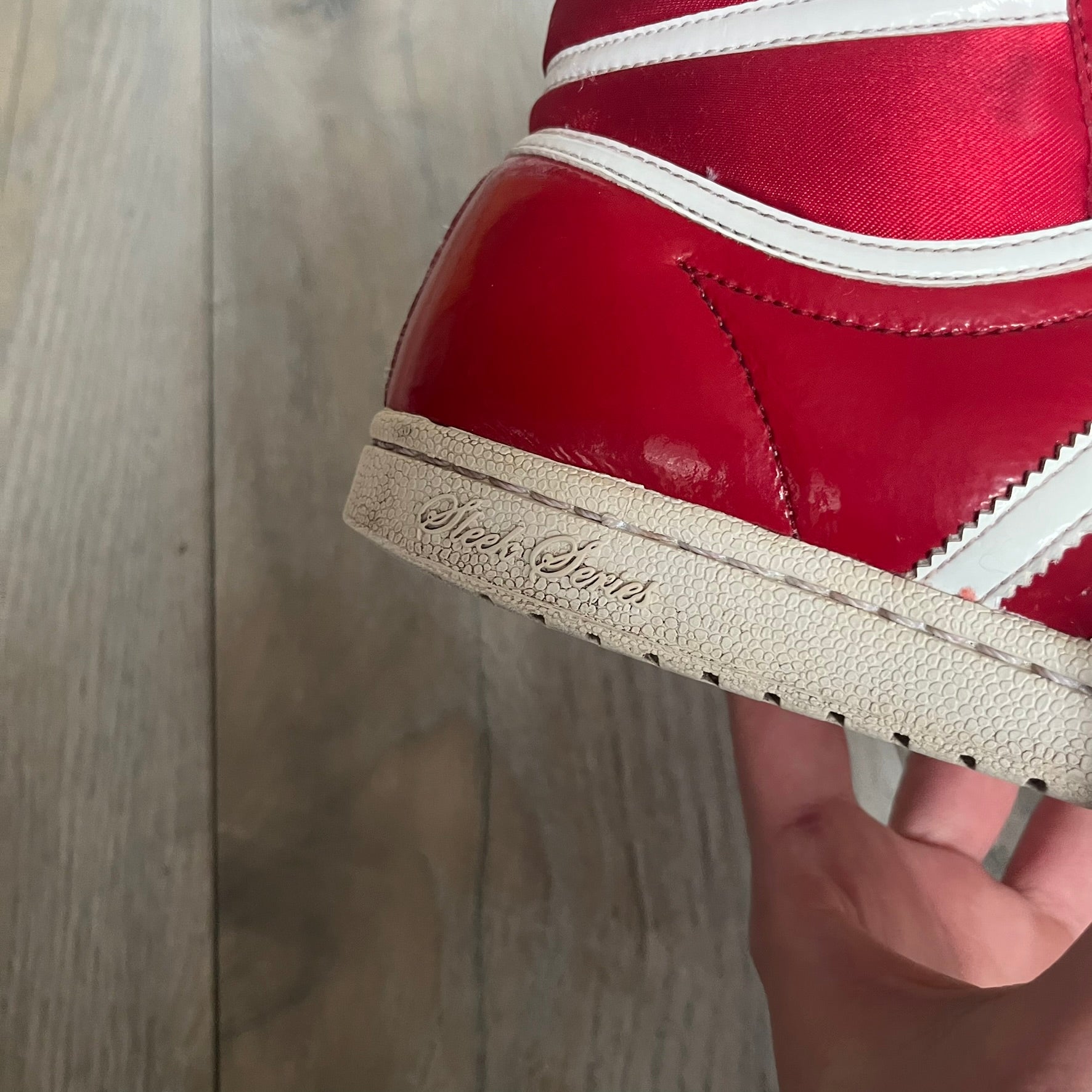 Adidas Originals Top Ten Hi Sleek Bow Sneakers are women’s high-top sneakers in University-Red and white leather. They feature a removable white bow on the tongue, white Adidas stripes, laces, and a white sole. Released under product number G61361, the sneakers include patent leather details for a polished finish.