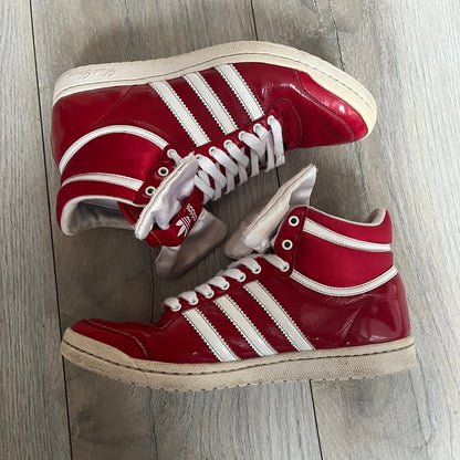 Adidas Originals Top Ten Hi Sleek Bow Sneakers are women’s high-top sneakers in University-Red and white leather. They feature a removable white bow on the tongue, white Adidas stripes, laces, and a white sole. Released under product number G61361, the sneakers include patent leather details for a polished finish.