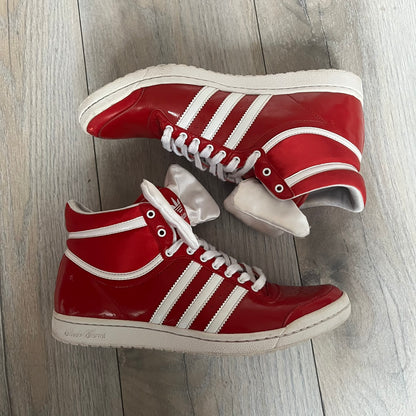 Adidas Originals Top Ten Hi Sleek Bow Sneakers are women’s high-top sneakers in University-Red and white leather. They feature a removable white bow on the tongue, white Adidas stripes, laces, and a white sole. Released under product number G61361, the sneakers include patent leather details for a polished finish.