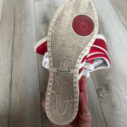 Adidas Originals Top Ten Hi Sleek Bow Sneakers are women’s high-top sneakers in University-Red and white leather. They feature a removable white bow on the tongue, white Adidas stripes, laces, and a white sole. Released under product number G61361, the sneakers include patent leather details for a polished finish.