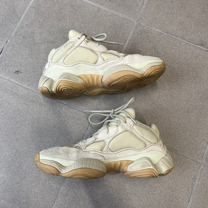 Adidas Yeezy 500 “Stone” Sneakers feature a Stone/Stone/Stone colorway with suede and neoprene paneling, reflective piping, and a pull-tab at the tongue. The sneakers have a lace-up fastening, adiPRENE midsole, and gum rubber outsole. Style FW4839, released November 23, 2019.

