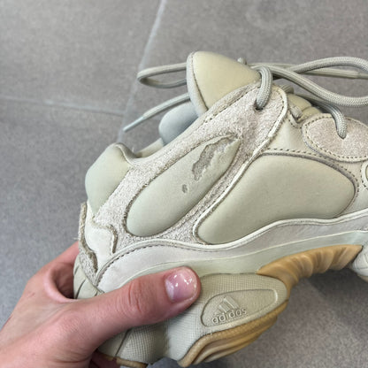 Adidas Yeezy 500 “Stone” Sneakers feature a Stone/Stone/Stone colorway with suede and neoprene paneling, reflective piping, and a pull-tab at the tongue. The sneakers have a lace-up fastening, adiPRENE midsole, and gum rubber outsole. Style FW4839, released November 23, 2019.
