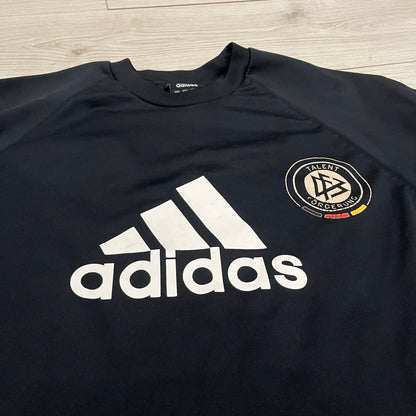 Adidas 2004/05 Germany Longsleeve in black featuring the Talent Förderung logo on the front and a center Adidas chest logo. Designed with classic three white stripes along the wrists and multiple sponsor logos on the back, including Mercedes, Adidas, and Nintendo. Made with Climawear fabric for comfort and performance.