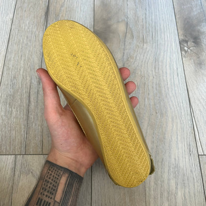 Adidas x Jeremy Scott 2011 Wings Gold Ballet Flats are a rare footwear design combining a classic ballet flat silhouette with Jeremy Scott’s signature wing motif. The shoes feature a fully metallic gold finish with visible stitching throughout the upper and wing construction. Small 3D wings extend from both sides of the heel area, creating the iconic Wings look in a streamlined form. Finished with a Trefoil Adidas logo on the back.
