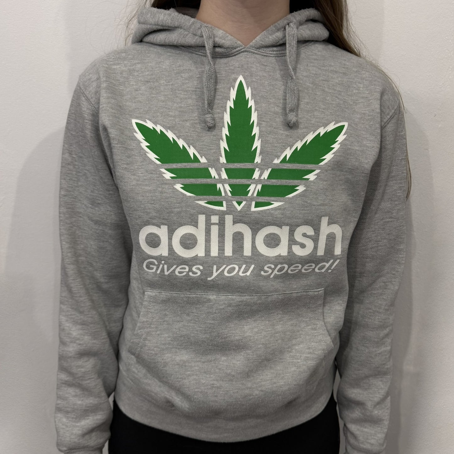 This Adihash “Gives You Speed!” Hoodie features a playful twist on the classic adidas emblem, replacing the trefoil with three marijuana leaves and big Adihash branding. Made from a soft polyester–cotton blend, it offers everyday comfort with a standard pouch pocket and a clean grey finish. Produced on a Lemon Collection blank.