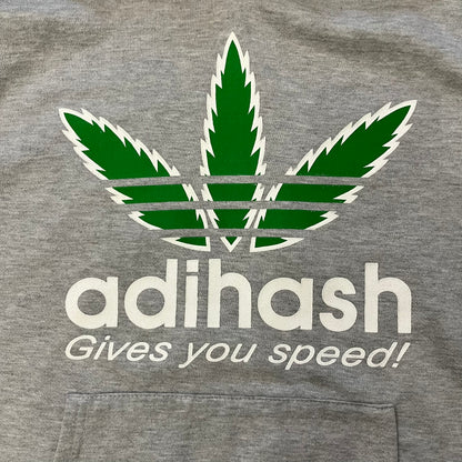 This Adihash “Gives You Speed!” Hoodie features a playful twist on the classic adidas emblem, replacing the trefoil with three marijuana leaves and big Adihash branding. Made from a soft polyester–cotton blend, it offers everyday comfort with a standard pouch pocket and a clean grey finish. Produced on a Lemon Collection blank.