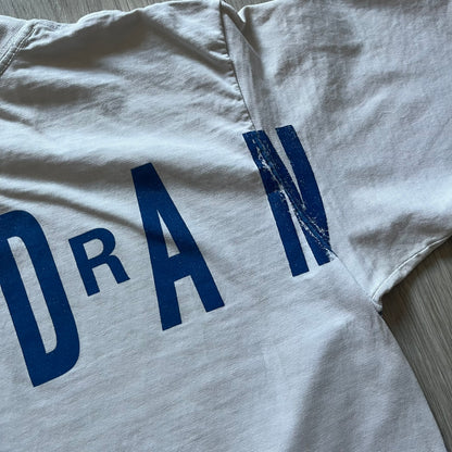 Air Jordan 2000’s All Over Print Tee featuring a bold full print of Michael Jordan in black, white, and blue across the front. A small red Jumpman logo sits at the bottom, while the back showcases a large Air Jordan logo with embroidered small red logo just under the collar. A rare vintage piece from the 2000s that captures peak Jordan era style.