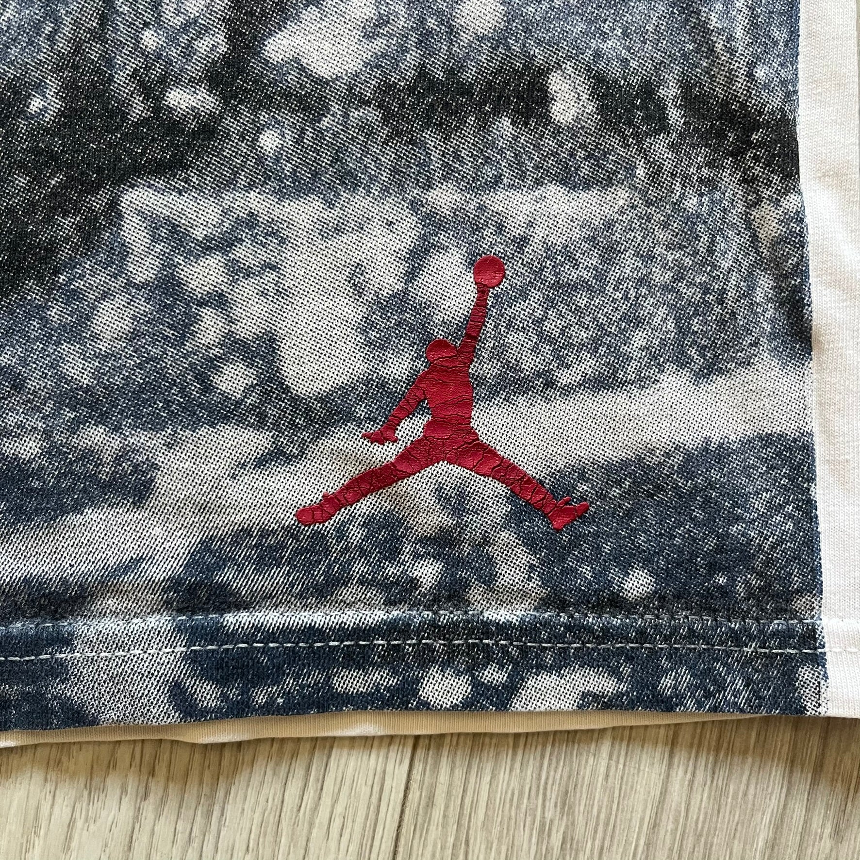 Air Jordan 2000’s All Over Print Tee featuring a bold full print of Michael Jordan in black, white, and blue across the front. A small red Jumpman logo sits at the bottom, while the back showcases a large Air Jordan logo with embroidered small red logo just under the collar. A rare vintage piece from the 2000s that captures peak Jordan era style.