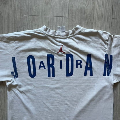 Air Jordan 2000’s All Over Print Tee featuring a bold full print of Michael Jordan in black, white, and blue across the front. A small red Jumpman logo sits at the bottom, while the back showcases a large Air Jordan logo with embroidered small red logo just under the collar. A rare vintage piece from the 2000s that captures peak Jordan era style.