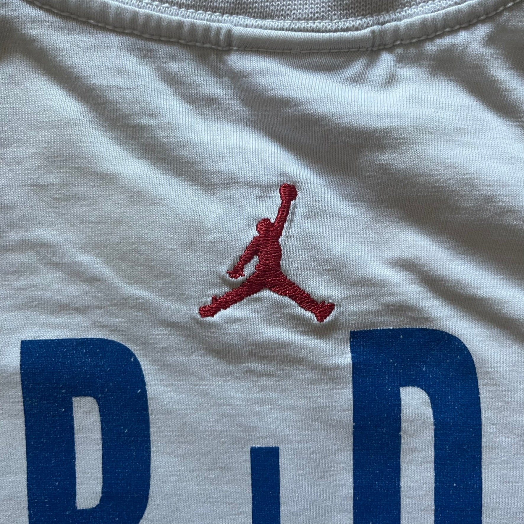 Air Jordan 2000’s All Over Print Tee featuring a bold full print of Michael Jordan in black, white, and blue across the front. A small red Jumpman logo sits at the bottom, while the back showcases a large Air Jordan logo with embroidered small red logo just under the collar. A rare vintage piece from the 2000s that captures peak Jordan era style.