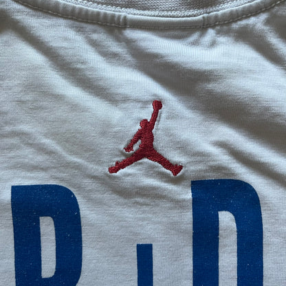 Air Jordan 2000’s All Over Print Tee featuring a bold full print of Michael Jordan in black, white, and blue across the front. A small red Jumpman logo sits at the bottom, while the back showcases a large Air Jordan logo with embroidered small red logo just under the collar. A rare vintage piece from the 2000s that captures peak Jordan era style.