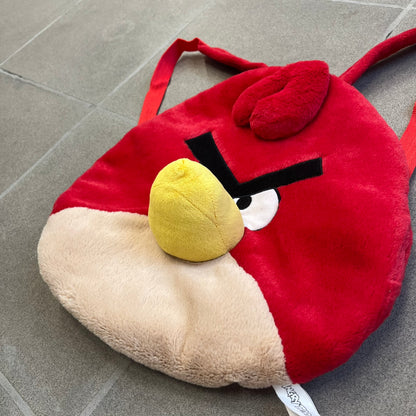 Angry Birds 2010s Red Bird Backpack is a small backpack shaped like Red, the iconic Angry Birds character. It features an angry facial expression with a three-dimensional beak and feather details, along with adjustable red shoulder straps. The interior includes official Angry Birds 2011 licensing.
