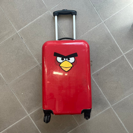 Angry Birds 2010s Red Bird Suitcase is a red rolling suitcase featuring the face of Red, the iconic Angry Birds character, on the front. It includes black wheels, a silver and black retractable handle, and an Angry Birds logo on the back. The interior features adjustable straps, zipped mesh compartments, and an all-over monogram lining with Angry Birds character patterns.