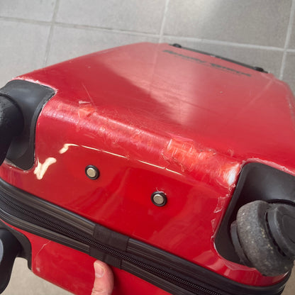 Angry Birds 2010s Red Bird Suitcase is a red rolling suitcase featuring the face of Red, the iconic Angry Birds character, on the front. It includes black wheels, a silver and black retractable handle, and an Angry Birds logo on the back. The interior features adjustable straps, zipped mesh compartments, and an all-over monogram lining with Angry Birds character patterns.