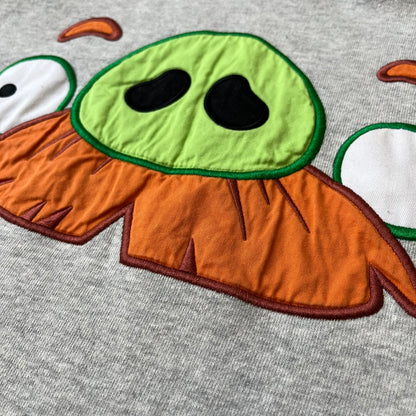 Angry Birds Three Star 2012 Foreman Pig Gray Hoodie features a grey hoodie design with a 3D-style front graphic of Foreman Pig, showing his recognizable eyes, nose, and mustache details. The back features a grey circular "Three Star" Angry Birds graphic, while the inside of the hood is finished with an orange lining.