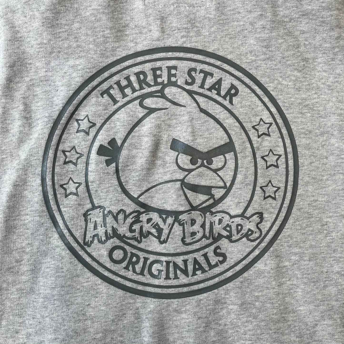 Angry Birds Three Star 2012 Foreman Pig Gray Hoodie features a grey hoodie design with a 3D-style front graphic of Foreman Pig, showing his recognizable eyes, nose, and mustache details. The back features a grey circular "Three Star" Angry Birds graphic, while the inside of the hood is finished with an orange lining.