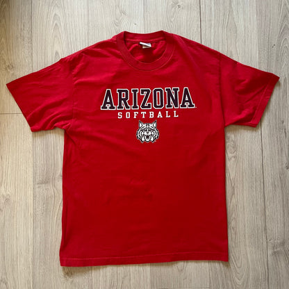 Red t-shirt with 'Arizona Softball' text and logo on a wooden surface