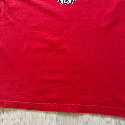 Red t-shirt with a logo on a wooden surface