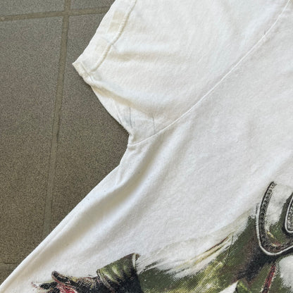 Assassin's Creed 2 Promo 2010 White Tee features a white 100% cotton construction with a large colorful graphic of Ezio Auditore da Firenze on the front. The Assassin's Creed 2 logo appears underneath the character, finished with a licensed neck tag.
