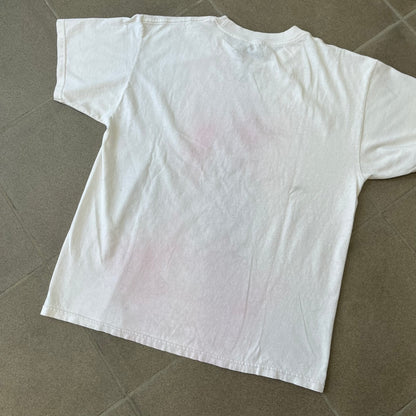 Assassin's Creed 2 Promo 2010 White Tee features a white 100% cotton construction with a large colorful graphic of Ezio Auditore da Firenze on the front. The Assassin's Creed 2 logo appears underneath the character, finished with a licensed neck tag.
