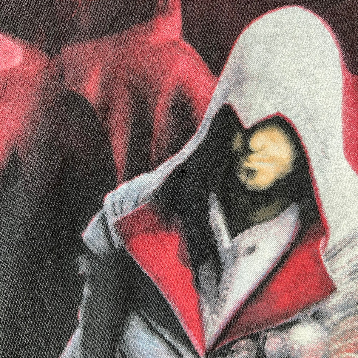 Assassin's Creed Brotherhood 2010 Black Promo Tee features a black construction with the Assassin's Creed Brotherhood cover printed on the front, showing Ezio Auditore with the large white and red text above him. Finished with a washed-off licensed neck tag