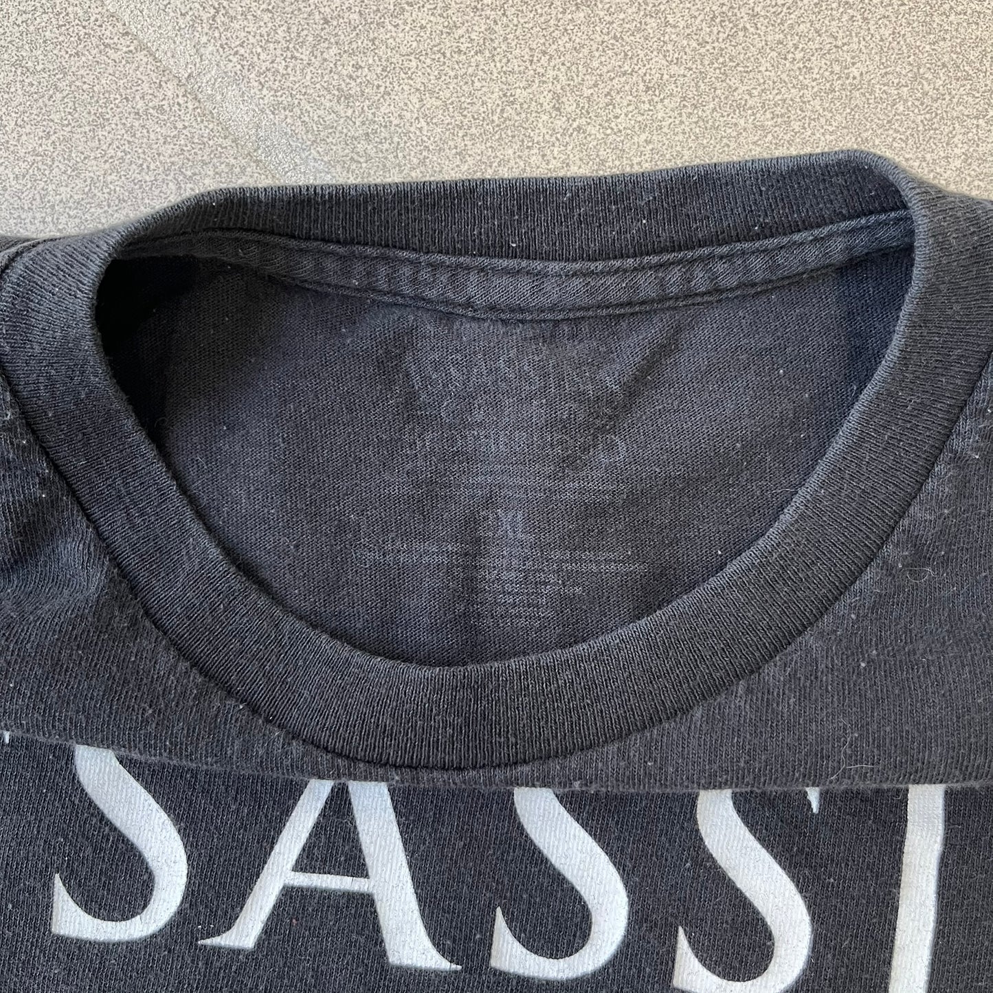 Assassin's Creed Brotherhood 2010 Black Promo Tee features a black construction with the Assassin's Creed Brotherhood cover printed on the front, showing Ezio Auditore with the large white and red text above him. Finished with a washed-off licensed neck tag