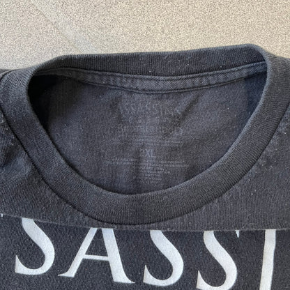 Assassin's Creed Brotherhood 2010 Black Promo Tee features a black construction with the Assassin's Creed Brotherhood cover printed on the front, showing Ezio Auditore with the large white and red text above him. Finished with a washed-off licensed neck tag