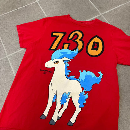 Asspizza 2024 Shiny Ponyta Red Tee is a red T-shirt featuring a shiny Ponyta graphic on the front with a yellow “730” number printed above. Next to the Ponyta graphic is a small black “Babbitt 2024 #077” text detail. The shirt is printed on a Colombia blank.
