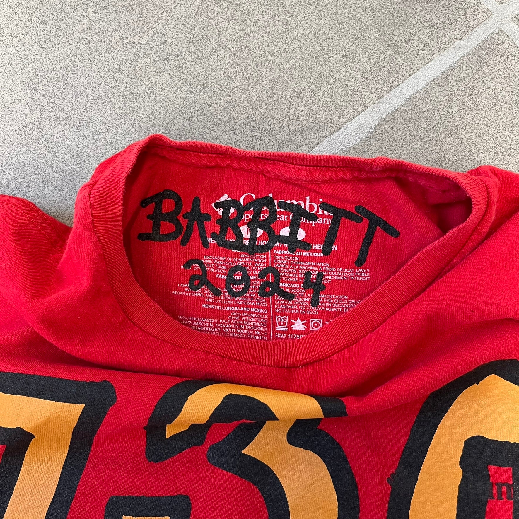 Asspizza 2024 Shiny Ponyta Red Tee is a red T-shirt featuring a shiny Ponyta graphic on the front with a yellow “730” number printed above. Next to the Ponyta graphic is a small black “Babbitt 2024 #077” text detail. The shirt is printed on a Colombia blank.
