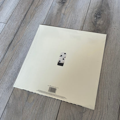 Baby Keem “Ca$ino” Exclusive Vinyl is a first print release from February 20, 2026, issued under pgLang (C-389572). The record includes an exclusive track “Tubi,” with additional audio differences such as extended talking on track A1 and an intro clip on track A5 not present on digital versions. The cover features Baby Keem on the front with a large “Parental Advisory” label, while the back displays two dice showing double twos.
