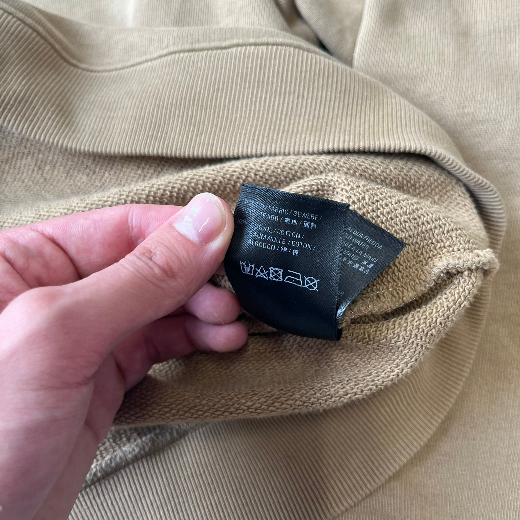 Balenciaga 2019 Khaki Small Logo Crewneck features a khaki 100% cotton construction with thick ribbed hems. A small black Balenciaga copyright logo is printed on the left chest. Made in Portugal.