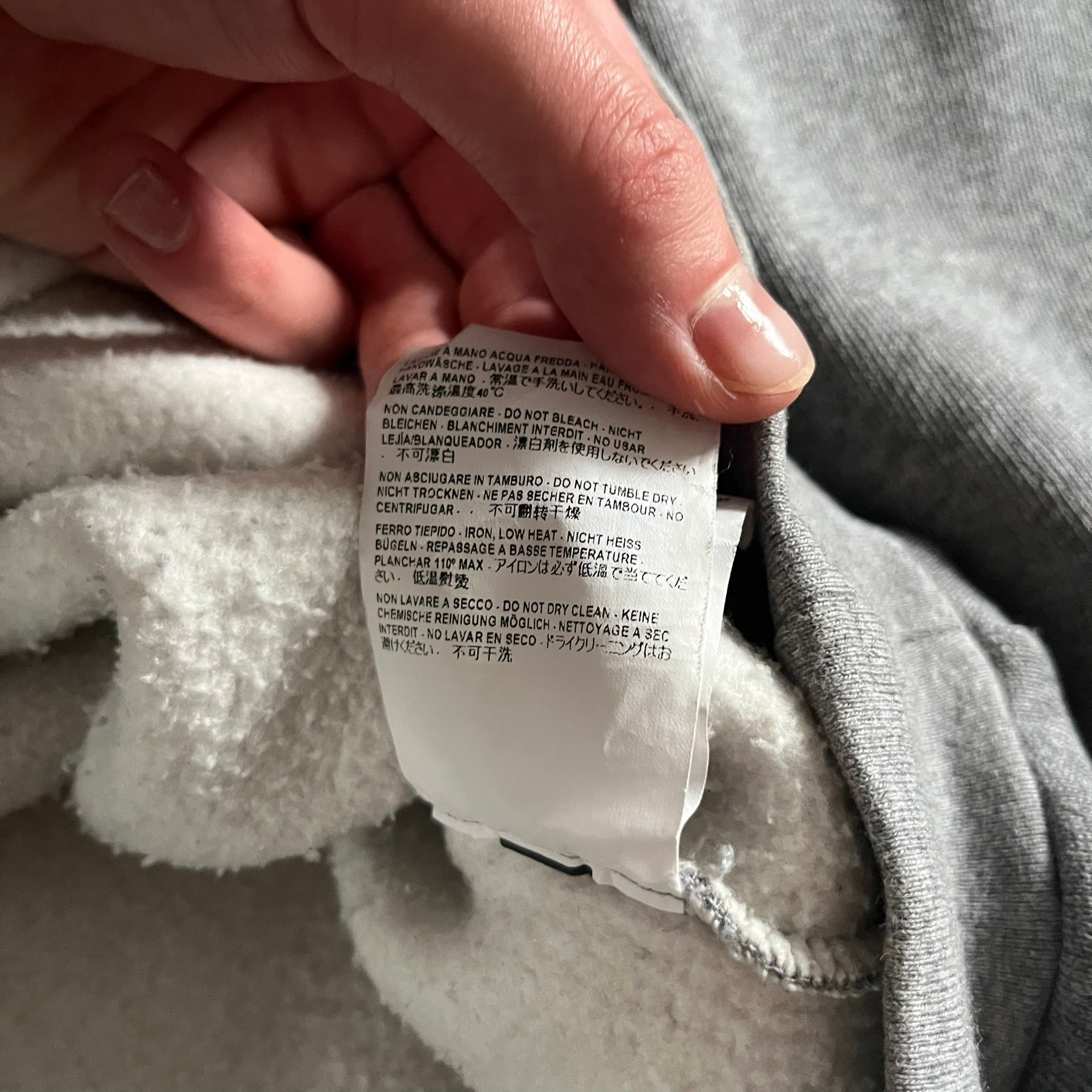 Balenciaga BB Crest Logo Hoodie in Heather Grey, crafted in Portugal from a heavyweight cotton-blend fleece (76% cotton, 24% polyester). The heather grey base features a dark navy BB emblem framed by laurel leaves and the Balenciaga logo text. Finished with dropped shoulders, ribbed edges, and a spacious front pocket, this oversized hoodie exemplifies elevated comfort and craftsmanship.