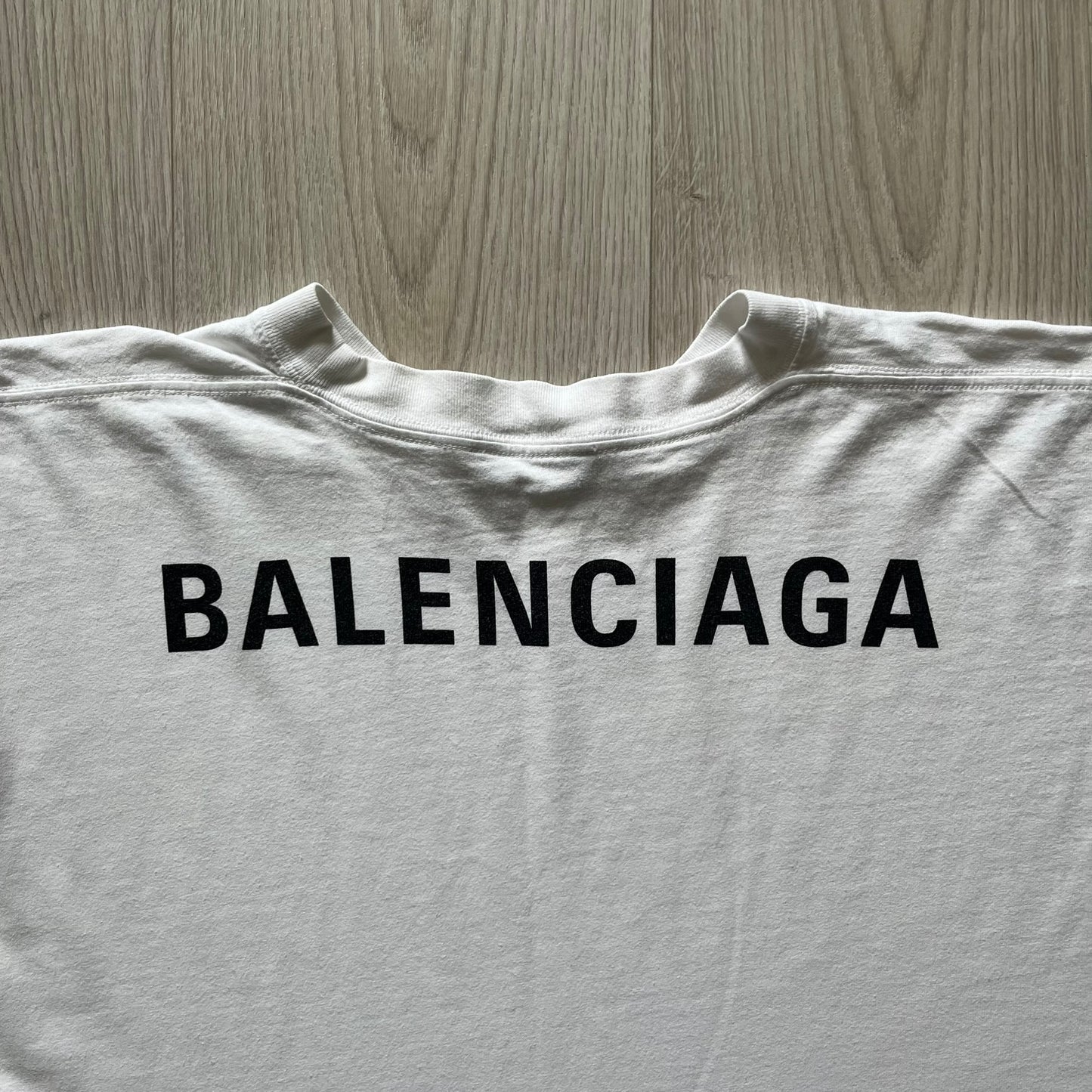 Balenciaga back logo tee from 2018, crafted in Portugal from soft white cotton. Designed with an oversized fit, it features a bold Balenciaga text logo across the upper back. Lower back part is a lot wider than front.