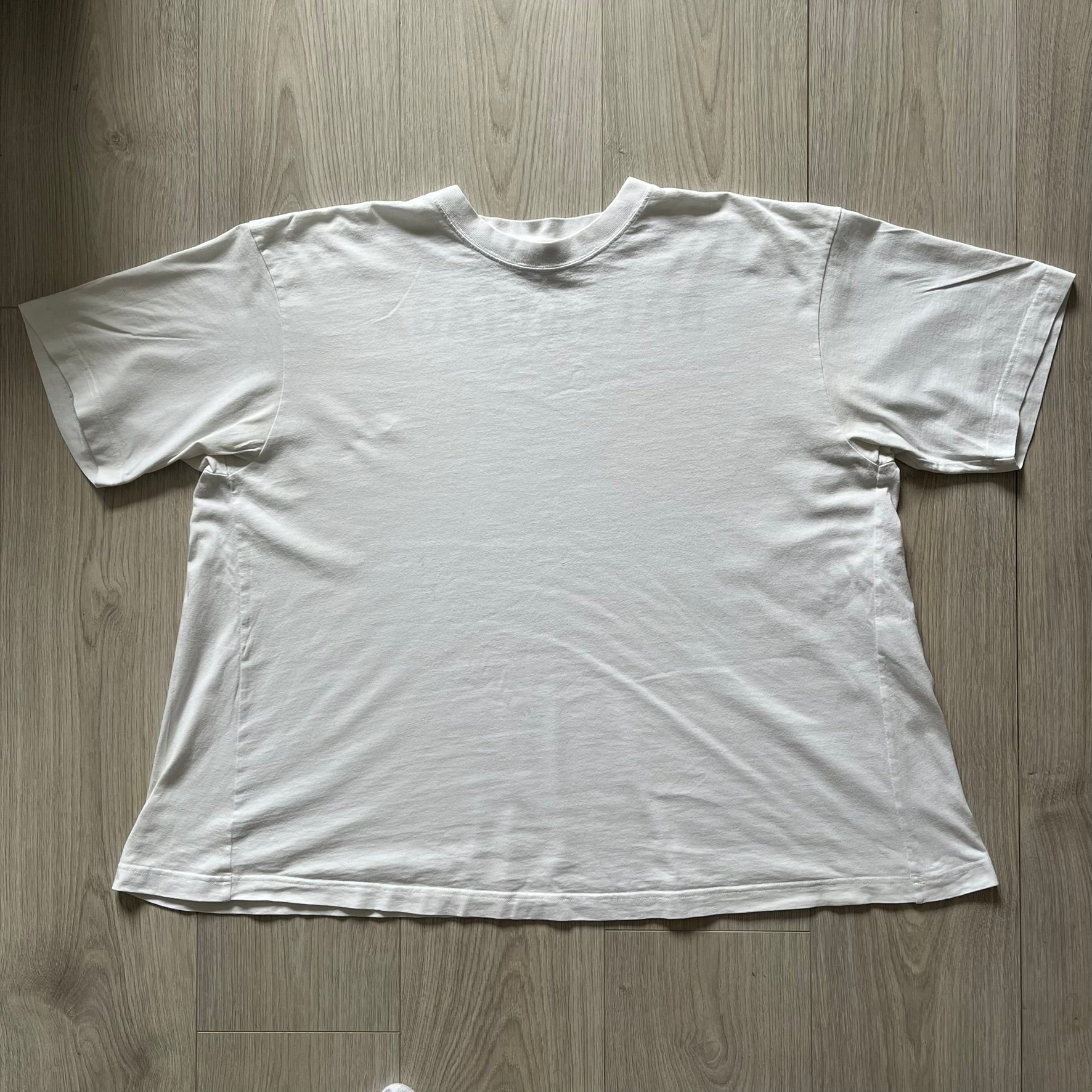 Balenciaga back logo tee from 2018, crafted in Portugal from soft white cotton. Designed with an oversized fit, it features a bold Balenciaga text logo across the upper back. Lower back part is a lot wider than front.