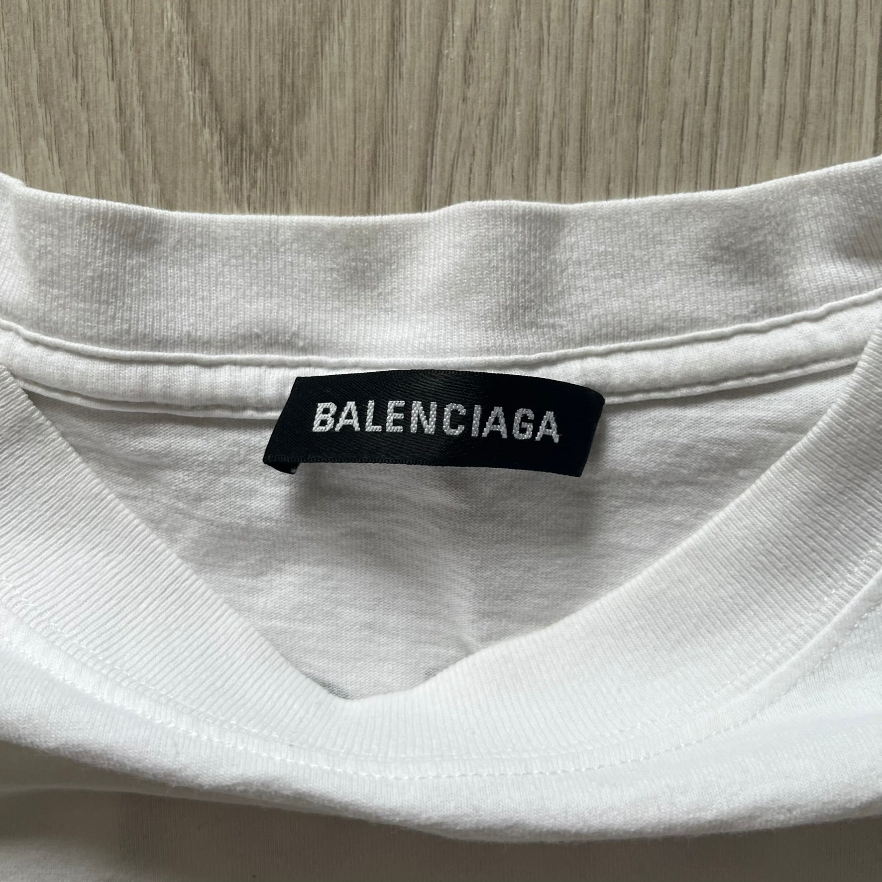 Balenciaga back logo tee from 2018, crafted in Portugal from soft white cotton. Designed with an oversized fit, it features a bold Balenciaga text logo across the upper back. Lower back part is a lot wider than front.