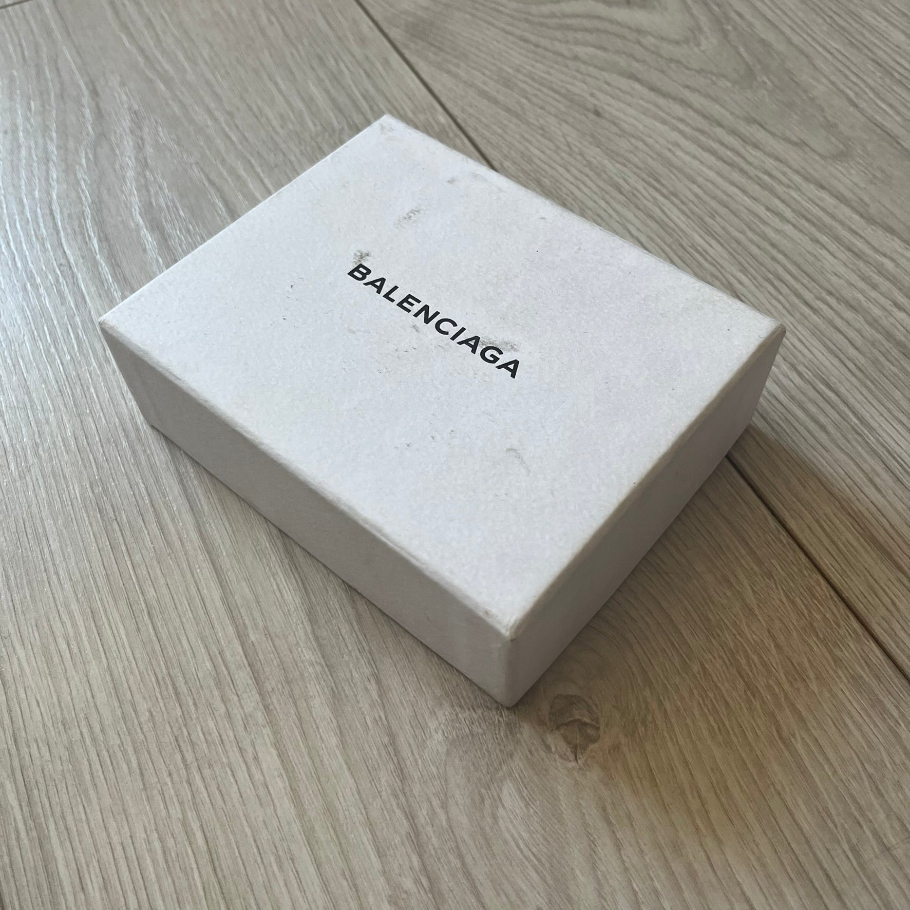  Balenciaga black leather card holder crafted in Italy from grained calfskin, featuring the updated Balenciaga logo in white inspired by public signage. Designed with four card slots and a central compartment, all fully lined in leather for durability. A sleek and practical accessory, it comes with a presentation box, reflecting Balenciaga’s modern luxury aesthetic under Demna Gvasalia’s creative direction.