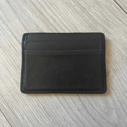  Balenciaga black leather card holder crafted in Italy from grained calfskin, featuring the updated Balenciaga logo in white inspired by public signage. Designed with four card slots and a central compartment, all fully lined in leather for durability. A sleek and practical accessory, it comes with a presentation box, reflecting Balenciaga’s modern luxury aesthetic under Demna Gvasalia’s creative direction.