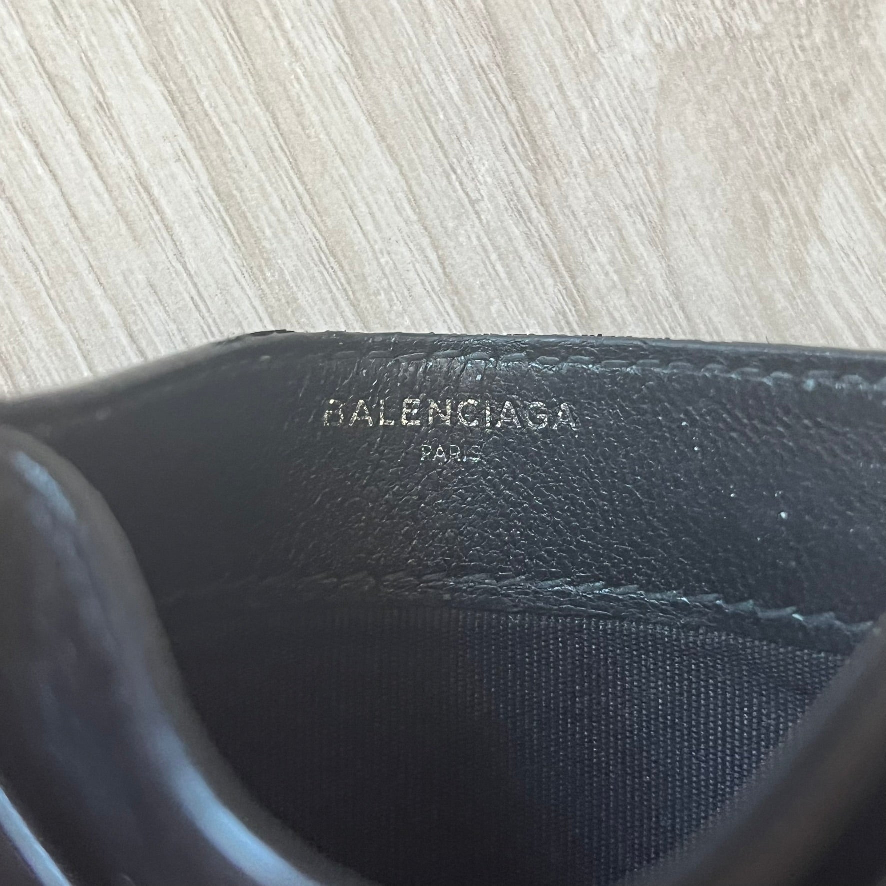  Balenciaga black leather card holder crafted in Italy from grained calfskin, featuring the updated Balenciaga logo in white inspired by public signage. Designed with four card slots and a central compartment, all fully lined in leather for durability. A sleek and practical accessory, it comes with a presentation box, reflecting Balenciaga’s modern luxury aesthetic under Demna Gvasalia’s creative direction.
