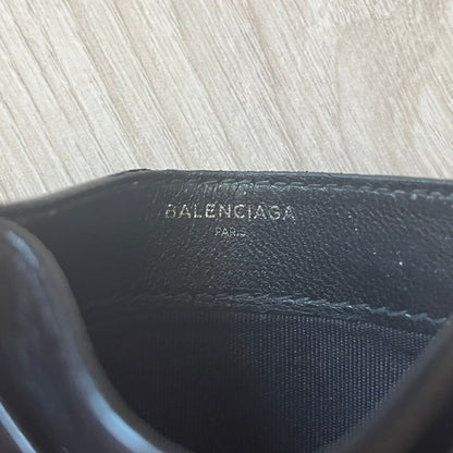 Balenciaga black leather card holder crafted in Italy from grained calfskin, featuring the updated Balenciaga logo in white inspired by public signage. Designed with four card slots and a central compartment, all fully lined in leather for durability. A sleek and practical accessory, it comes with a presentation box, reflecting Balenciaga’s modern luxury aesthetic under Demna Gvasalia’s creative direction.