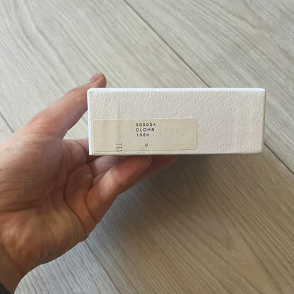  Balenciaga black leather card holder crafted in Italy from grained calfskin, featuring the updated Balenciaga logo in white inspired by public signage. Designed with four card slots and a central compartment, all fully lined in leather for durability. A sleek and practical accessory, it comes with a presentation box, reflecting Balenciaga’s modern luxury aesthetic under Demna Gvasalia’s creative direction.