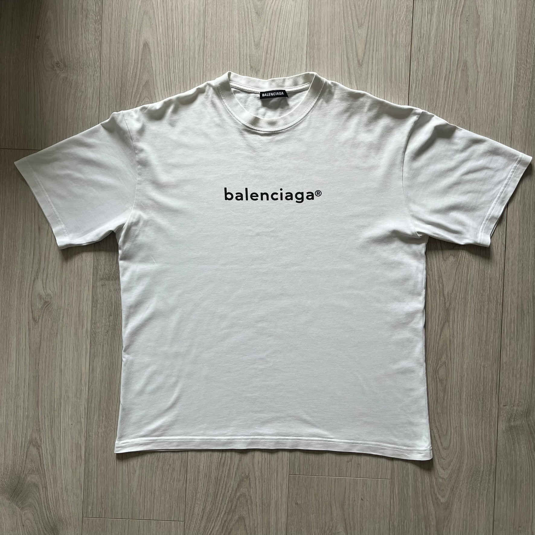 Balenciaga white copyright tee from the Autumn/Winter 2020 collection, crafted in Portugal from premium cotton. Featuring the house’s minimalist design, it’s finished with simple black “Balenciaga” text and a copyright logo on the chest. A clean and high-quality essential.