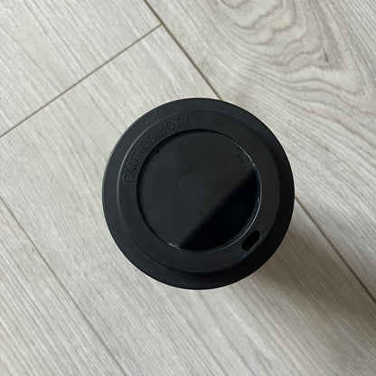 Balenciaga Dallas Black Coffee Cup crafted from glossy black porcelain with a white interior. Features a bold white Balenciaga logo with “Dallas” text underneath and a matching black rubber lid. A refined collectible showcasing everyday luxury.&nbsp;